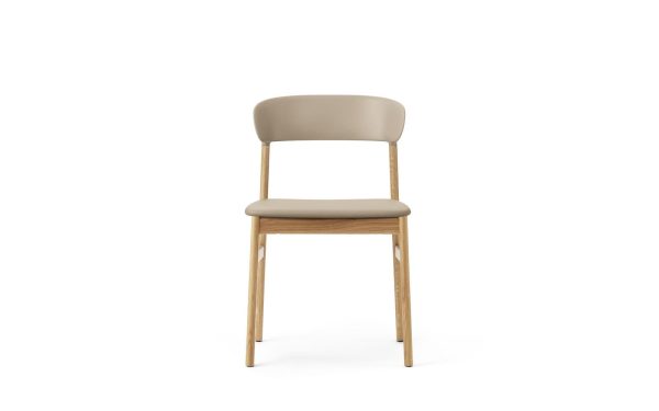 En moderne stol med en beige hynde og træben, isoleret på en hvid baggrund. Stolen har et enkelt, elegant interiørdesign med let buet ryglæn.