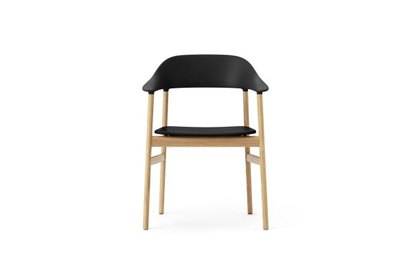 En moderne spisestuestol med sort sæde og ryglæn med lyse træben, sat mod en almindelig hvid baggrund, der illustrerer et upåklageligt design.