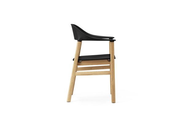 En moderne design barstol med sort sæde og lys træramme, vist på hvid baggrund. Skamlen har et slankt design med et let buet ryglæn og vandrette fodstøttestænger.