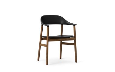 En moderne stol designet med et sort plastik ryglæn og sæde, sat på en træramme med fire ben, isoleret på en hvid baggrund.