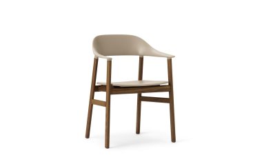 En moderne stol med et beige plastiksæde og ryglæn, med et designorienteret træstel med fire ben, isoleret på en hvid baggrund.