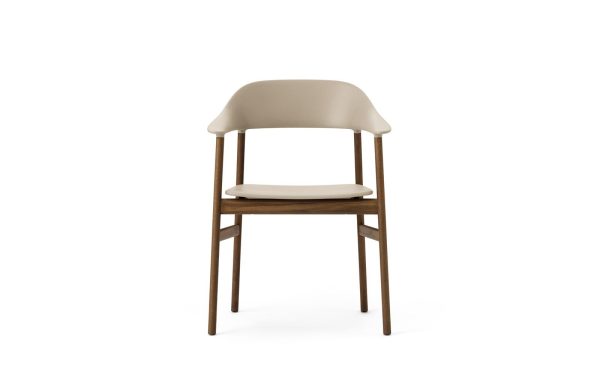 En moderne stol med træben og en buet, beige plastikryg og sædehynde, isoleret på en hvid baggrund. Dette stykke afspejler moderne design æstetik.