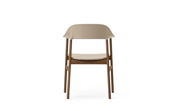 En moderne stol med en beige plastikskal og et brunt træstel, sat mod en almindelig hvid baggrund. Stolen, en del af TomorrowsDesign-kollektionen, har et buet ryglæn og et fladt sæde.