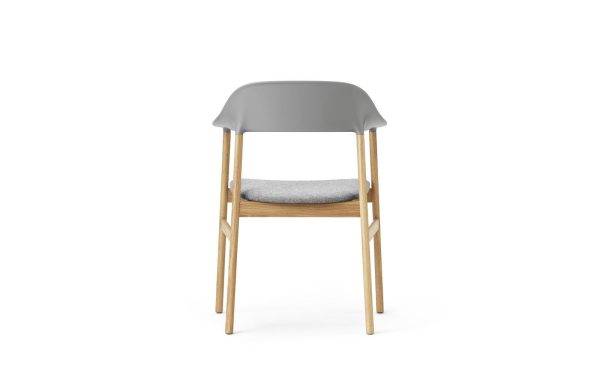 En moderne stol med træben og et gråt plastikryglæn, designet af TomorrowsDesign, med et polstret sæde med lysegråt stof, isoleret på en hvid baggrund.