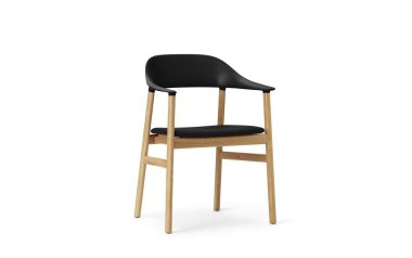 En moderne stol med sort sæde og ryglæn, monteret på en lys træramme med fire ben, vist på en ren, hvid baggrund af TomorrowsDesign.