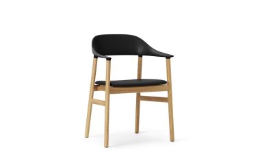 En moderne stol med sort sæde og ryglæn på en lys træramme, afbilledet på en almindelig hvid baggrund, viser skandinavisk møbler design.