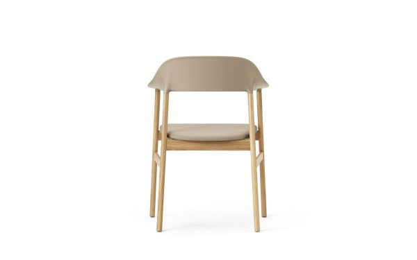 EN NORMANN COPENHAGEN - Herit Spisebordsstol med beige plastik ryglæn og sædehynde, parret med lyse træben, isoleret på en hvid baggrund.