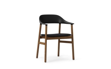En moderne barstol med sort sæde og ryglæn og en træramme, isoleret på en hvid baggrund, fremviser udsøgte designmøbler.
