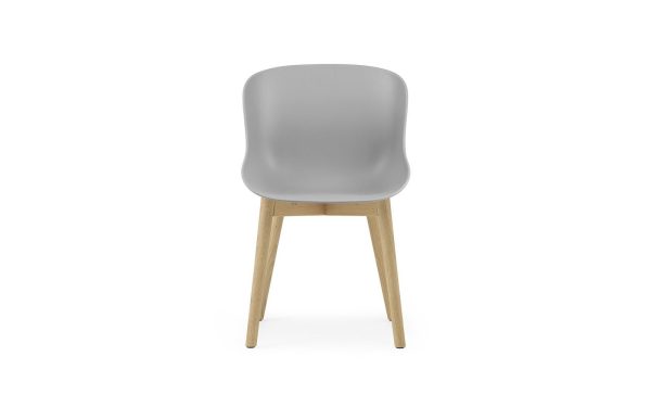 En moderne NORMANN COPENHAGEN - Hyg Spisebordsstol med gråt plastiksæde og ryglæn monteret på fire træben. stolen er centreret på en hvid baggrund, let vendt mod venstre.