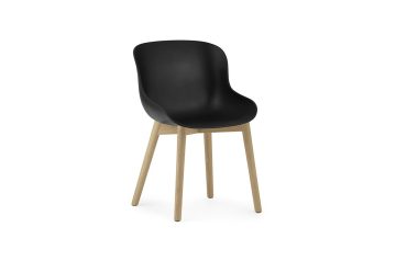 En moderne stol med NORMANN COPENHAGEN - Hyg Spisebordsstol sæde og lyse træben, placeret på en hvid baggrund.