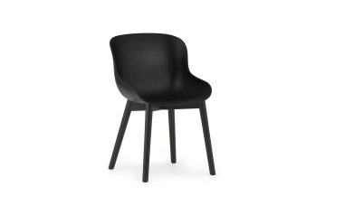 En moderne sort stol med glat, buet ryglæn og fire slanke ben, med et unikt design, isoleret på en hvid baggrund.