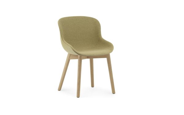 En moderne spisestuestol med lyse træben og et buet, polstret sæde i et afdæmpet grønt stof, isoleret på en hvid baggrund. Dette stykke viser banebrydende design fra TomorrowsDesign.