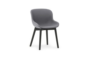 En moderne NORMANN COPENHAGEN - Hyg Spisebordsstol med glat, buet ryglæn og sæde på fire sorte ben, isoleret mod en hvid baggrund.