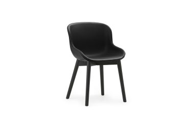 En moderne sort stol med glat, buet ryglæn og fire slanke ben, isoleret på en hvid baggrund. Dette stykke er et højdepunkt i moderne møbeldesign.