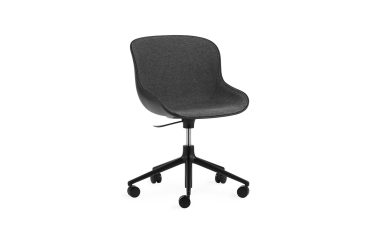 EN NORMANN COPENHAGEN - Hyg Stol med gråt stofsæde og sort base, med justerbare højdeindstillinger og drejehjul, isoleret på en hvid baggrund.