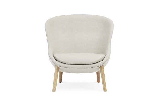 En moderne beige lænestol med buet ryg og træben, isoleret på en hvid baggrund, perfekt til moderne interiørdesign.