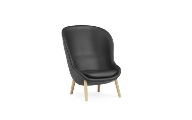 Et moderne NORMANN COPENHAGEN - Hyg Lænestol High med høj, buet ryg og træben, isoleret på hvid baggrund.