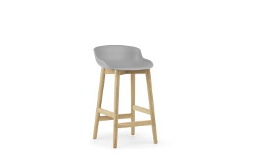 En moderne grå barstol med buet sæde og træben, med skandinavisk interiørdesign, isoleret på en hvid baggrund.