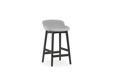 En moderne barstol med gråt polstret sæde og sorte træben fra TomorrowsDesign, isoleret på hvid baggrund.