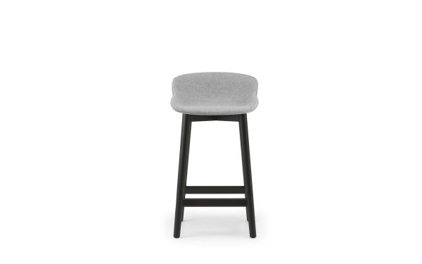 En moderne barstol med sort stel og lysegrå polstret sæde, isoleret på en hvid baggrund, eksemplificerer moderne designmøbler.
