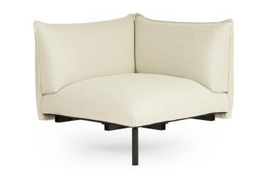 Moderne hjørnestol med en beige stofhynde og høje sidepaneler i wingback-stil, sat på et minimalt sort stel. designet er NORMANN COPENHAGEN - Ark Modular Sofa 150 Hjørne og funktionelt.