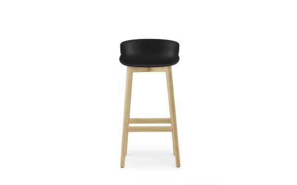 En moderne barstol med et sort sæde og ben af naturtræ, fotograferet på en hvid baggrund, præsenteret af TomorrowsDesign.