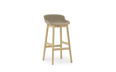 En moderne design barstol med beige polstret sæde og træben på hvid baggrund.