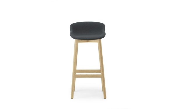 EN NORMANN COPENHAGEN - Hyg Barstol 75 med et mørkegrå polstret sæde og en lys træramme, stående mod en hvid baggrund.