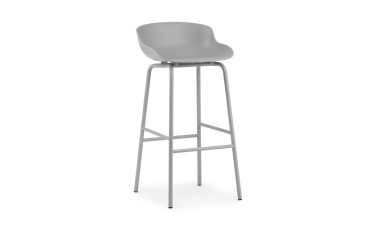 En moderne NORMANN COPENHAGEN - Hyg Barstol 75 med buet plastiksæde og slanke metalben på hvid baggrund.