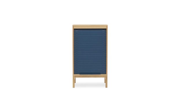 Et træskab med en blå tambourdør på hvid baggrund. Skabet står oprejst med slanke ben og udviser et minimalistisk TomorrowsDesign.