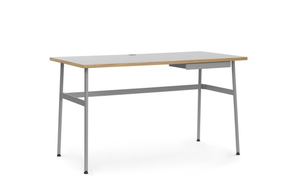 Et moderne kontorbord med en beige top og grå metalramme, med en lille skuffe på højre side og justerbare ben, sat mod en almindelig hvid baggrund. Dette stykke eksemplificerer moderne designmøbler-æstetik.