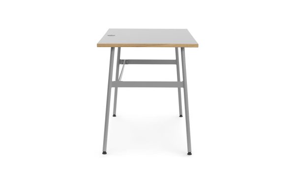 Et moderne, minimalistisk skrivebord med en let træbordplade og grå metalramme, med integreret beskedenhedspanel og et lille kabelstyringshul på toppen. Møblerne er vist på hvid baggrund.