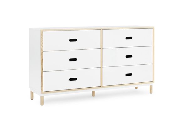 En moderne hvid kommode med seks skuffer med sorte hanke, indrammet i lyst træ, stående på fire træben, isoleret på en hvid baggrund, fra TomorrowsDesign.