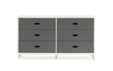 EN NORMANN COPENHAGEN - Kabino Kommode med seks skuffer, med tre grå skuffer på hver side adskilt af en hvid lodret skillevæg, sat oven på lyse træben, isoleret på en hvid baggrund.