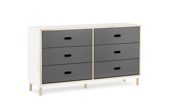 En moderne NORMANN COPENHAGEN - Kabino Kommode med en hvid ramme, med seks grå skuffer arrangeret i to søjler, hver med et udskåret håndtag, stående på korte træben.