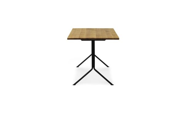 Et firkantet træbord med en lysebrun plade i slagterblokstil og en sort metalbund, der deler sig i fire ben i et fladt krydsformet arrangement, designet som et elegant stykke møbler, isoleret på en hvid baggrund.