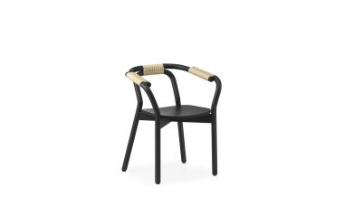 En moderne NORMANN COPENHAGEN - Knot Spisebordsstol med buet ryglæn og armlæn, med vævede accenter på armene, placeret mod en almindelig hvid baggrund.