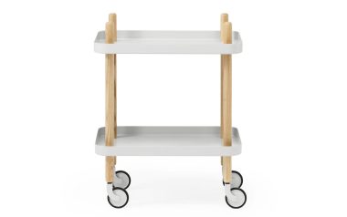 Et moderne to-lags NORMANN COPENHAGEN - Block Rullebord med en lysegrå finish og ben i naturligt træ, med fire sorte hjul til mobilitet. vognen er placeret mod en ren, hvid baggrund.