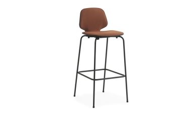 En brun polstret barstol med et højt sort metalstel og fodstøtte fra TomorrowsDesign, isoleret på hvid baggrund.