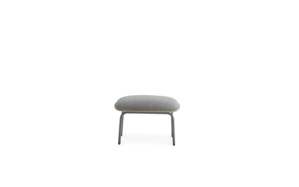 EN NORMANN COPENHAGEN - Pad Fodskammel med gråt polstret sæde og tynde metalben, sat mod en almindelig hvid baggrund.