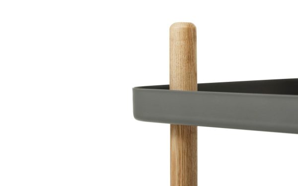 Nærbillede af et minimalistisk moderne møbler, der viser en træstolpe, der understøtter et gråt vandret element, muligvis en hylde, mod en hvid baggrund.