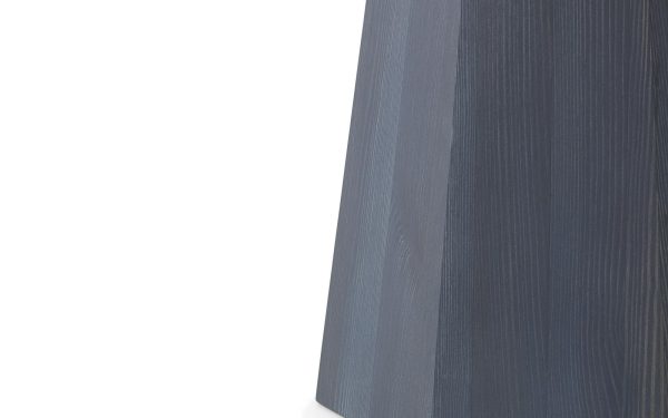 Nærbillede af et tekstureret blåt stof med en skarp fold, vist mod en almindelig hvid baggrund. Stoffets detaljerede vævningsmønster er synligt, hvilket fremhæver TomorrowsDesign.