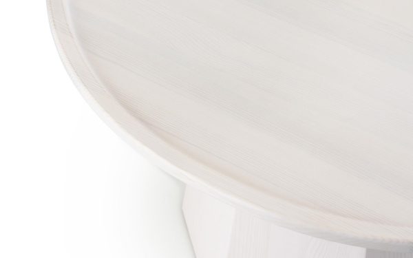 Nærbillede af en NORMANN COPENHAGEN - Pine Sofabord Ø65 med en tekstureret overflade, vist i en minimalistisk, high-key belysningsopsætning.