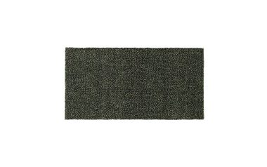 Et nærbillede af en tæt tekstureret NORMANN COPENHAGEN - Polli Gulvtæppe 100x200 overflade, der viser et ensartet mønster af syntetiske græsstrå.