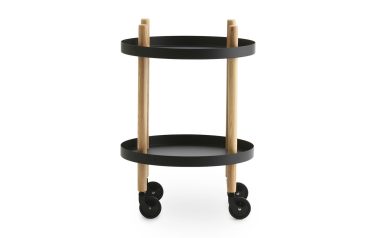 Et moderne NORMANN COPENHAGEN - Blok Rullebord Ø45 med sorte cirkulære hylder og naturtræstolper, udstyret med fire sorte styrehjul til mobilitet, isoleret på en hvid baggrund.