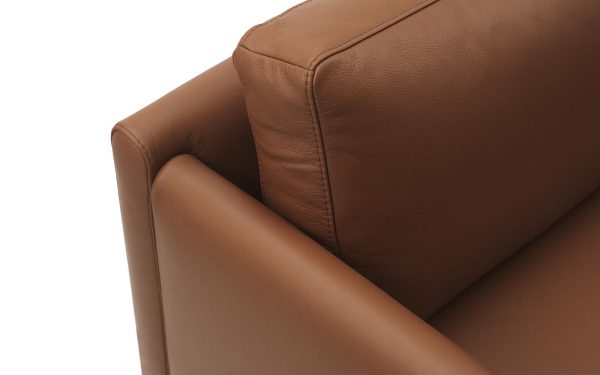 Nærbillede af hjørnet af en brun lædersofa, der viser tekstureret polstring og rene syningsdetaljer fra TomorrowsDesign.
