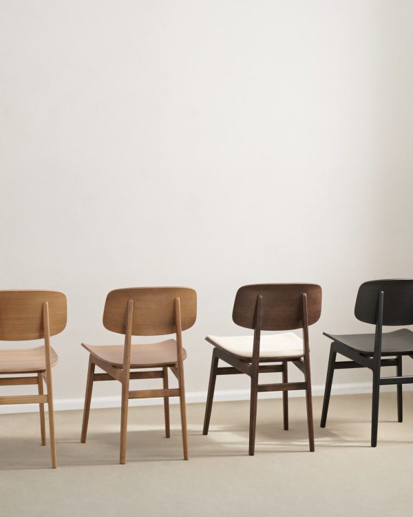Fire NORR11 - NY11 Spisebordsstol stole i forskelligt design mod neutral baggrund, arrangeret på række fra lyse til mørke trætoner, med en sort stol for enden.