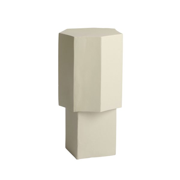 En minimalistisk skulptur, der ligner en stiliseret figur med rektangulær krop og hoved, præsenteret i en monokromatisk, bleg beige farve og isoleret mod en almindelig hvid baggrund.