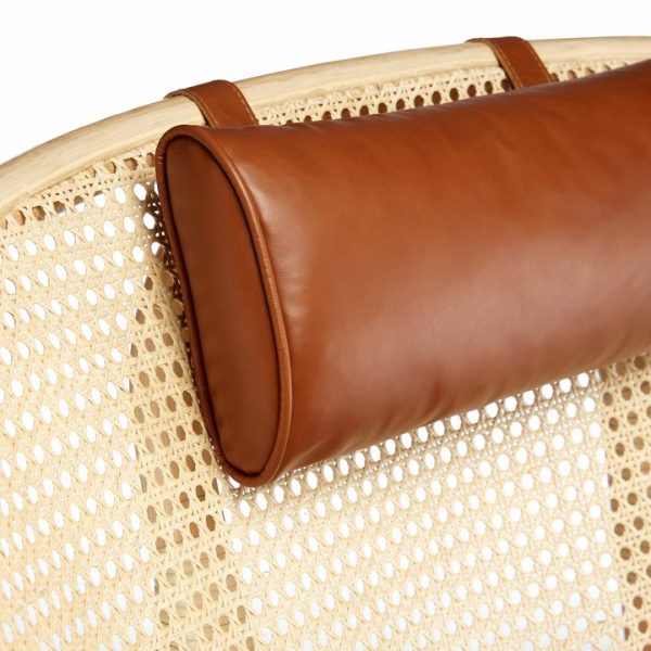 Nærbillede af en brun læderpude, der hviler på en beige rodoverflade, der fremhæver kontrasten af teksturer mellem det glatte læder og det mønstrede stokværk, der inkarnerer TomorrowsDesign-etos.