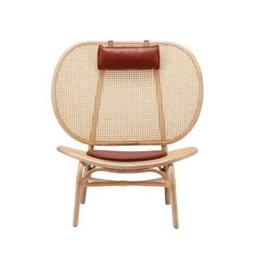 En moderne rattanstol med en afrundet ryg med et stokbåndsdesign, suppleret med en brun læder-nakkestøtte og matchende sædehynde, sat mod en hvid baggrund. Dette stykke viser udsøgt møbler håndværk.